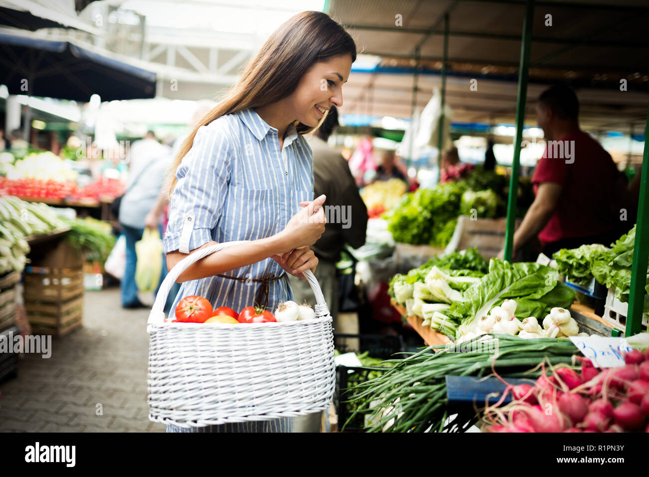 Junge Frau kaufen Gemüse auf dem Markt. Stockfoto