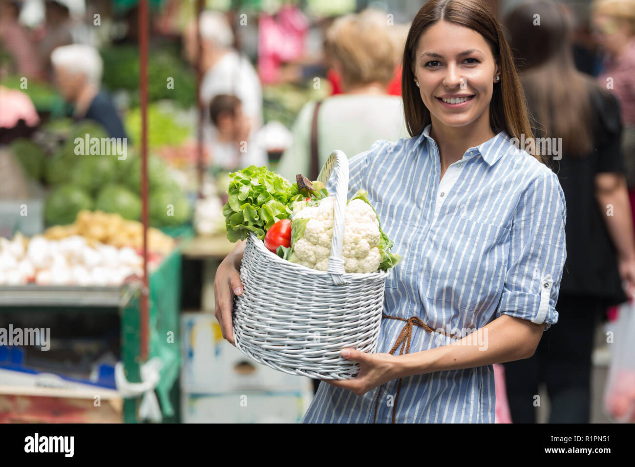 Junge Frau kaufen Gemüse auf dem Markt. Stockfoto
