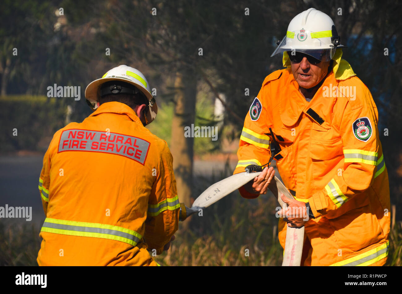 Freiwillige Feuerwehr von St Georges Basin Arbeit den Schlauch an einem Fahrzeug Feuer an Jervis Bay, NSW, Australien - 12 Dez 2017 zu verbinden. Stockfoto