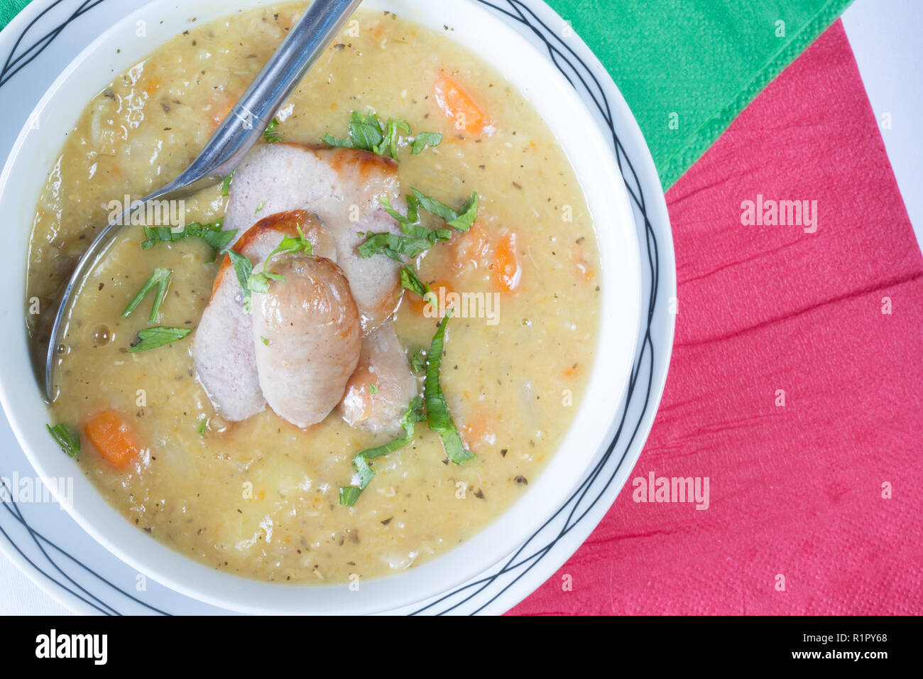 Polnische Zurek oder Gemüsesuppe mit Wurst und Petersilie garnieren. Stockfoto