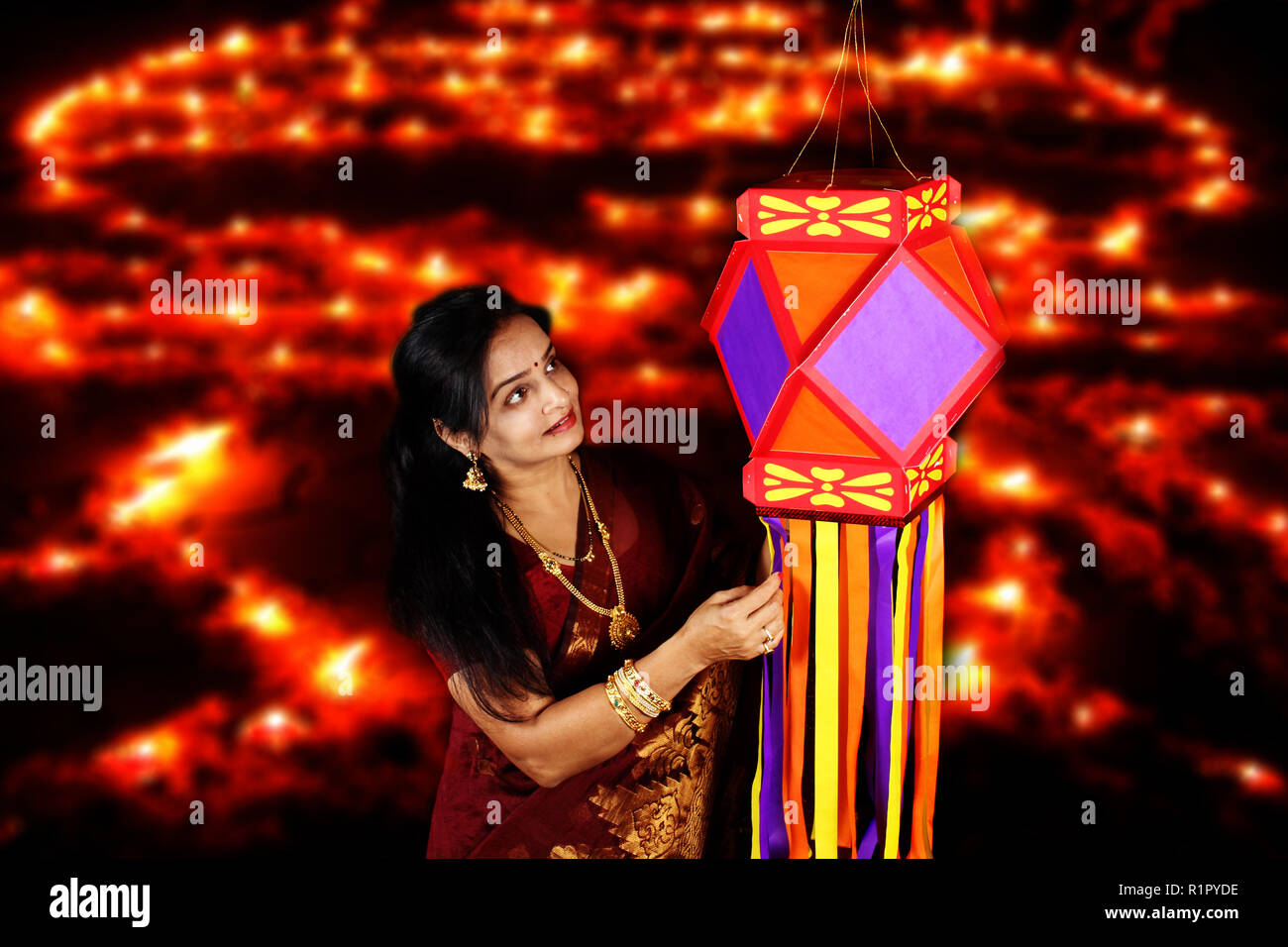 Eine indische Frau mittleren Alters, bewundern Sie die traditionelle Laterne in Ihrem Haus, am Vorabend von Diwali Festival in Indien. Stockfoto