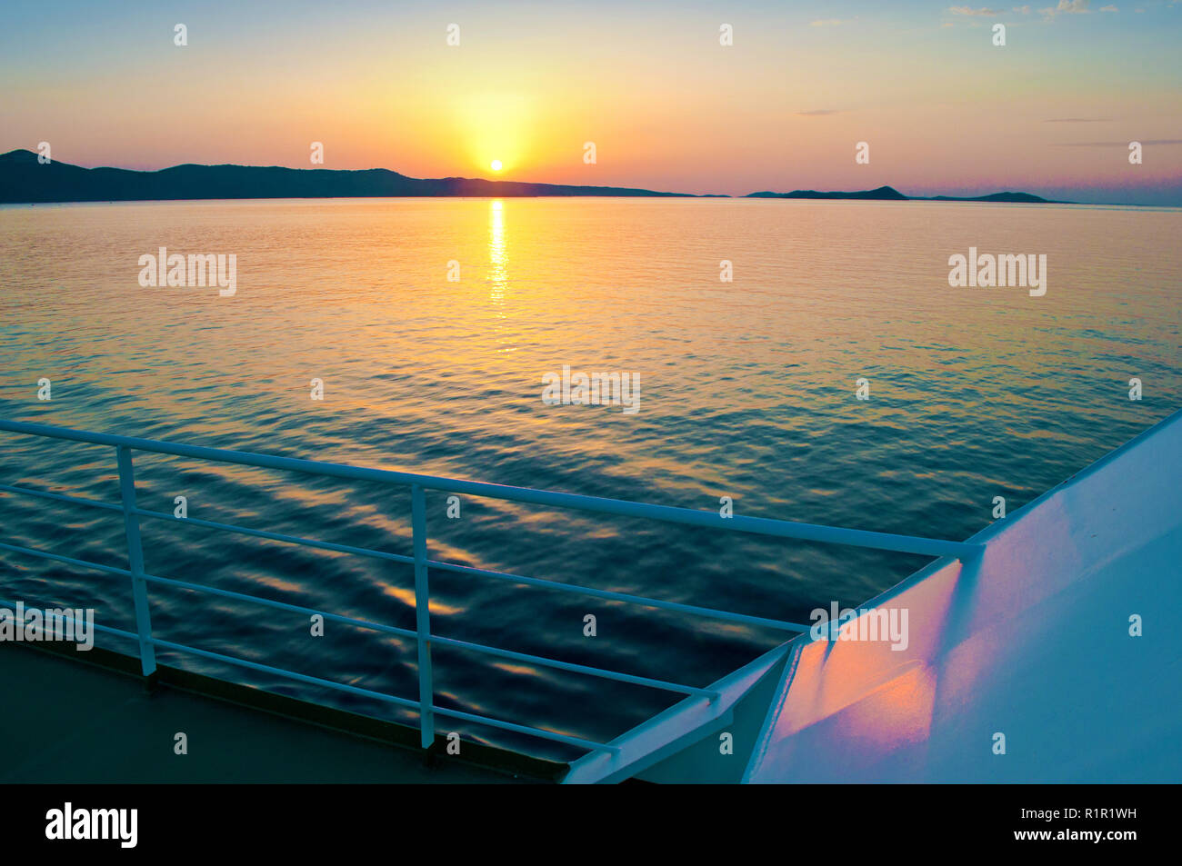 Sonnenuntergang über einem Hügel im Meer in der Nähe der Küste von Kroatien. Bild vom Deck eines Schiffes Stockfoto