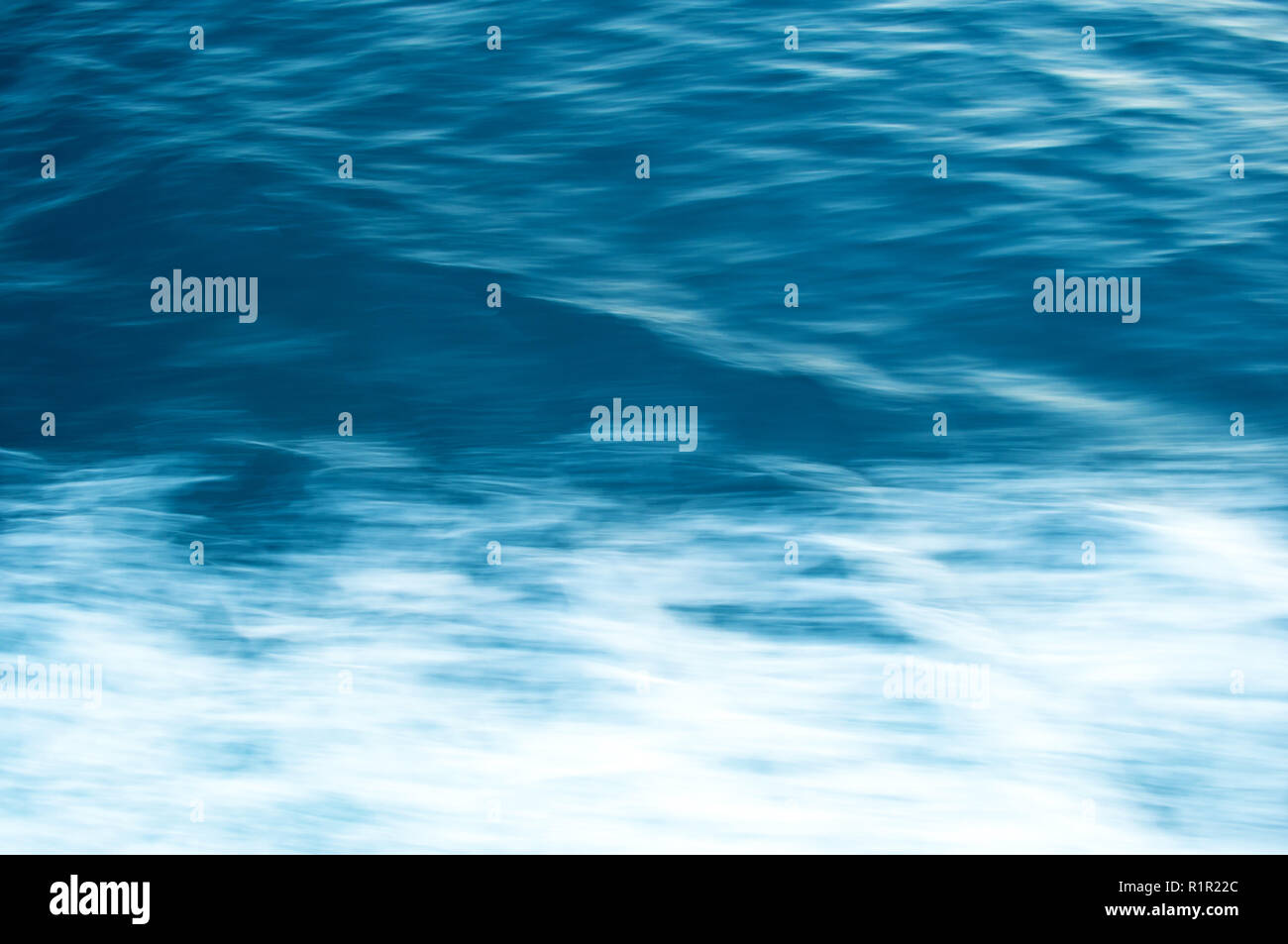 Hintergrund einer unscharfen wellige Wasseroberfläche mit weißer Schaum Stockfoto