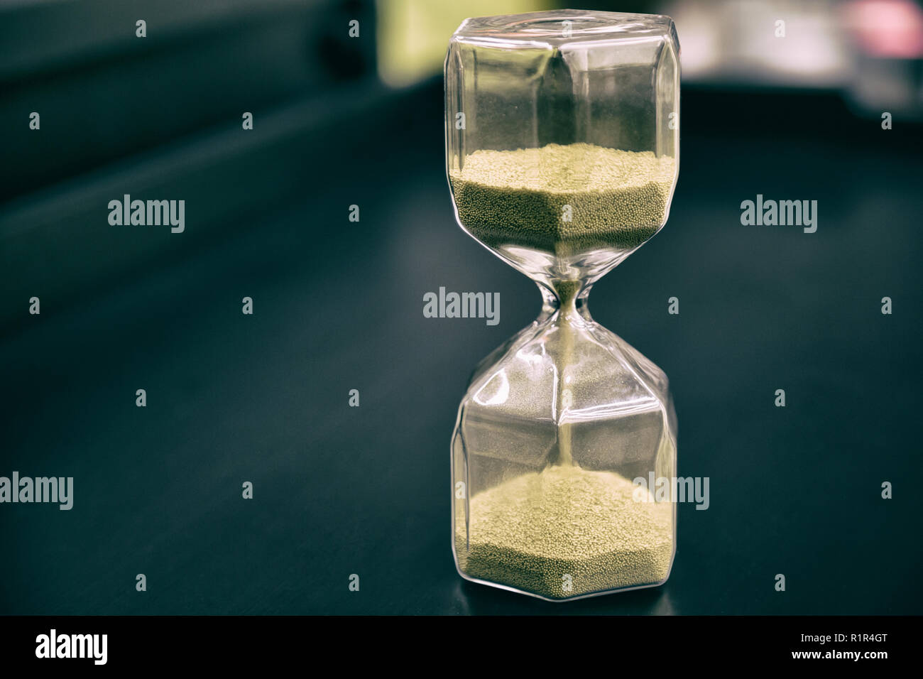 Sanduhr am rustikalen Holztisch. Die Zeit wird knapp oder Termin Konzept. Nahaufnahme Stockfoto