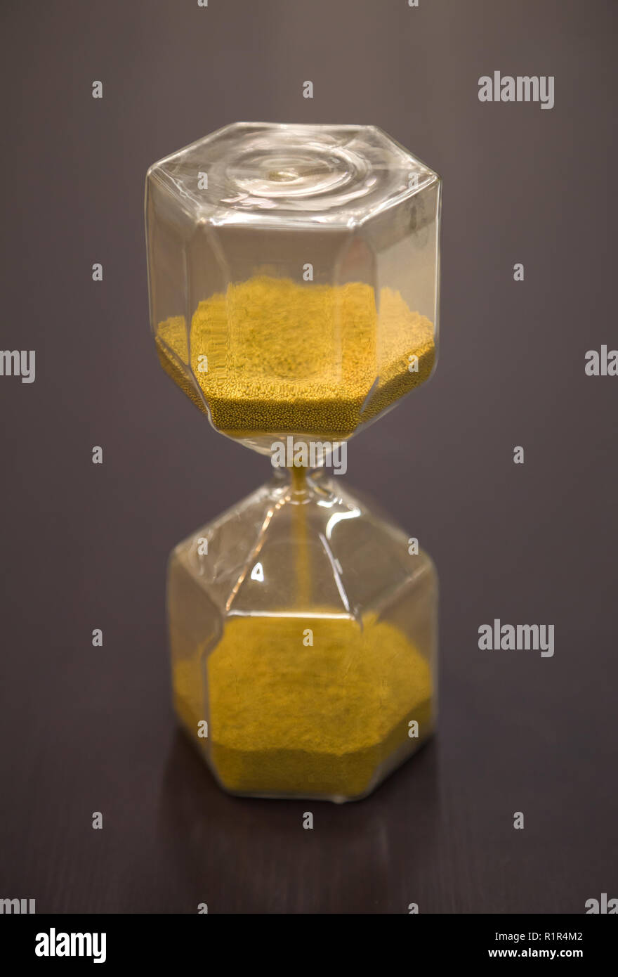 Sanduhr am rustikalen Holztisch. Die Zeit wird knapp oder Termin Konzept. Nahaufnahme Stockfoto