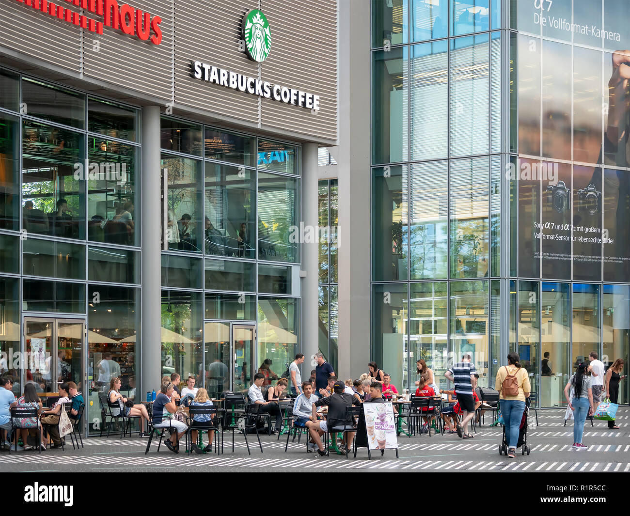 BERLIN, DEUTSCHLAND - 3. AUGUST 2018: Leute, die sich vor Starbucks Café am Potsdamer Platz in Berlin, Deutschland Stockfoto