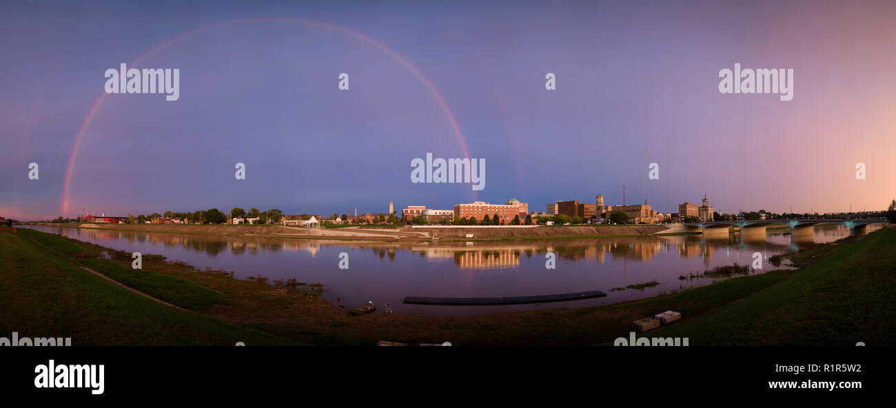 Ein Regenbogen erscheint über Hamilton, Ohio und den Großen Miami River nach einem Sturm, während die Sonne untergeht. Stockfoto
