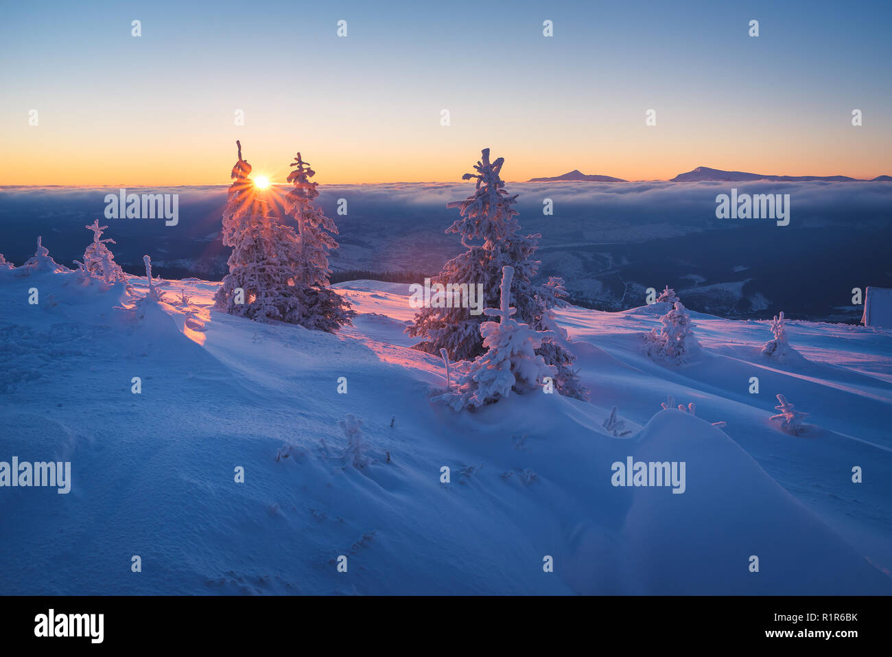 Frostigen morgen in den Bergen. Landschaft mit der aufgehenden Sonne. Schneereiche Winter Stockfoto