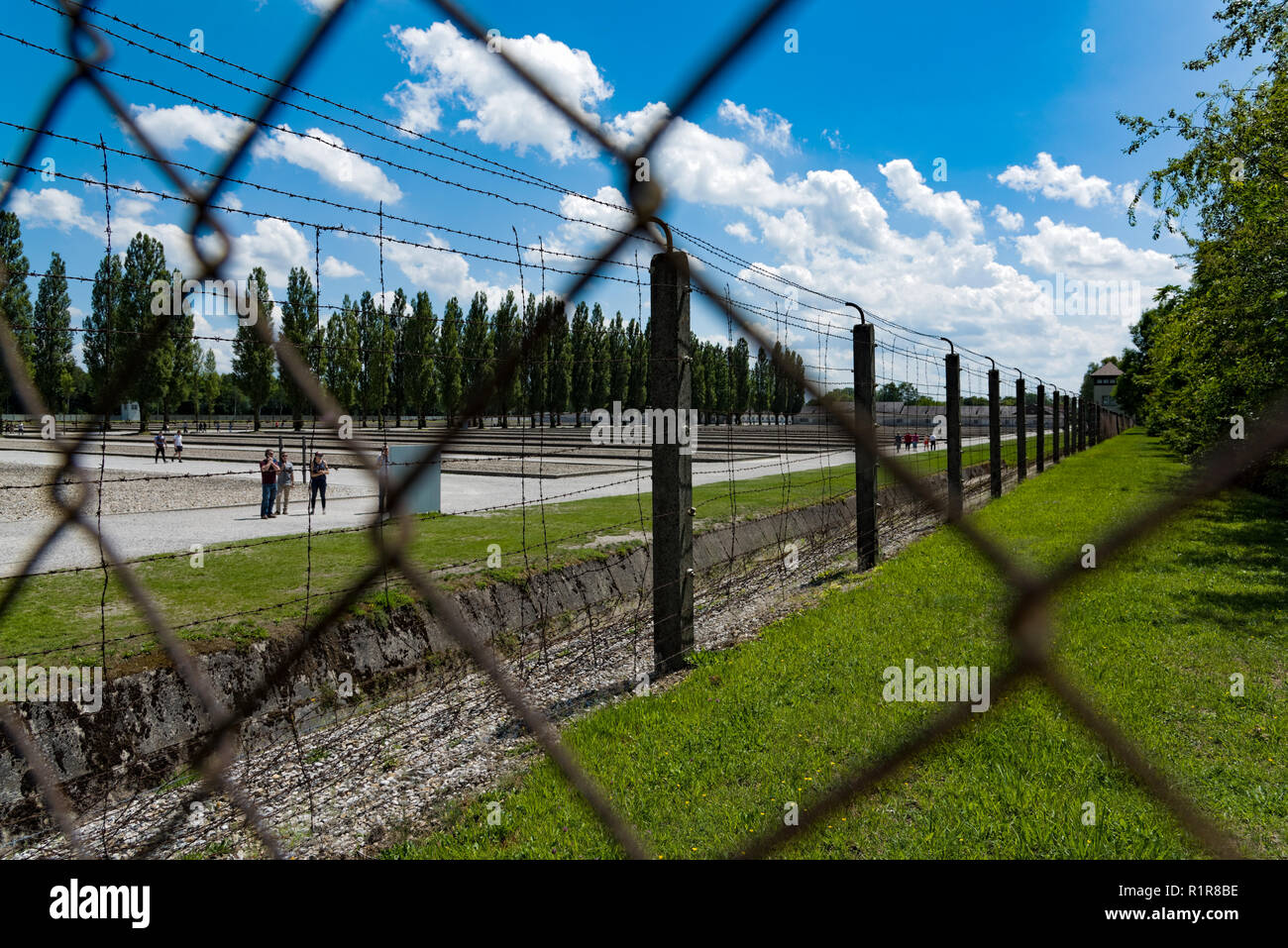 Die Besucher gehen entlang der Zaun des Konzentrationslagers Dachau bei München in Deutschland am 3. Juni 2018 Stockfoto