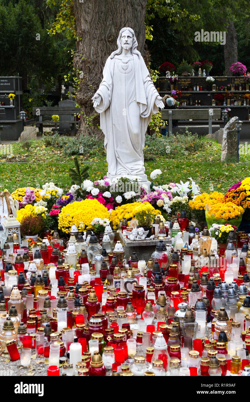 Eine Statue des Heiligsten Herzens Jesu an Martinsky cintorin (Friedhof), während der alle Seelen Oktave. Anzünden Kerzen sind. Stockfoto