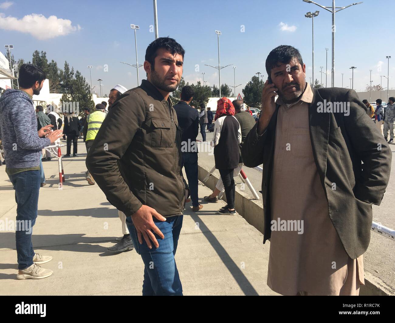 Kabul, Afghanistan. 14 Nov, 2018. Marawat Khumarkhel (r), eine ausgefallene Afghanische Asylbewerber aus Deutschland abgeschoben, wartet auf einen Anruf Familie Mitglieder zu informieren, dass er in der afghanischen Hauptstadt nach der Landung am Flughafen angekommen. Er gehört zu einer Gruppe von 42 Asylbewerber, die zurück nach Afghanistan von Deutschland aus geflogen wurden. Credit: Mohammad Jawad/dpa/Alamy leben Nachrichten Stockfoto