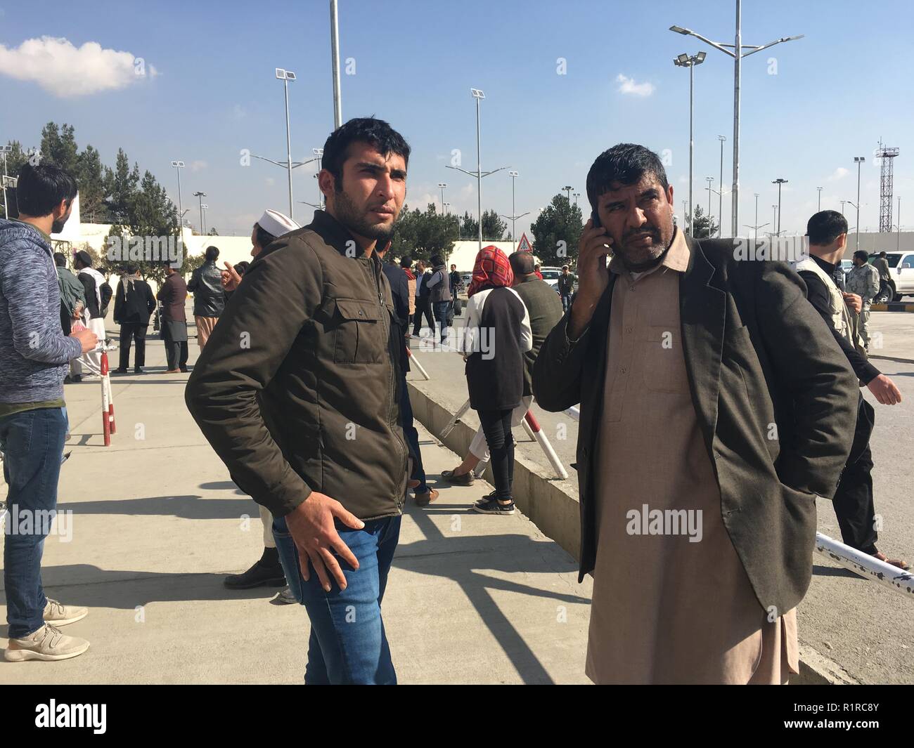 Kabul, Afghanistan. 14 Nov, 2018. Marawat Khumarkhel (r), eine ausgefallene Afghanische Asylbewerber aus Deutschland abgeschoben, wartet auf einen Anruf Familie Mitglieder zu informieren, dass er in der afghanischen Hauptstadt nach der Landung am Flughafen angekommen. Er gehört zu einer Gruppe von 42 Asylbewerber, die zurück nach Afghanistan von Deutschland aus geflogen wurden. Credit: Mohammad Jawad/dpa/Alamy leben Nachrichten Stockfoto