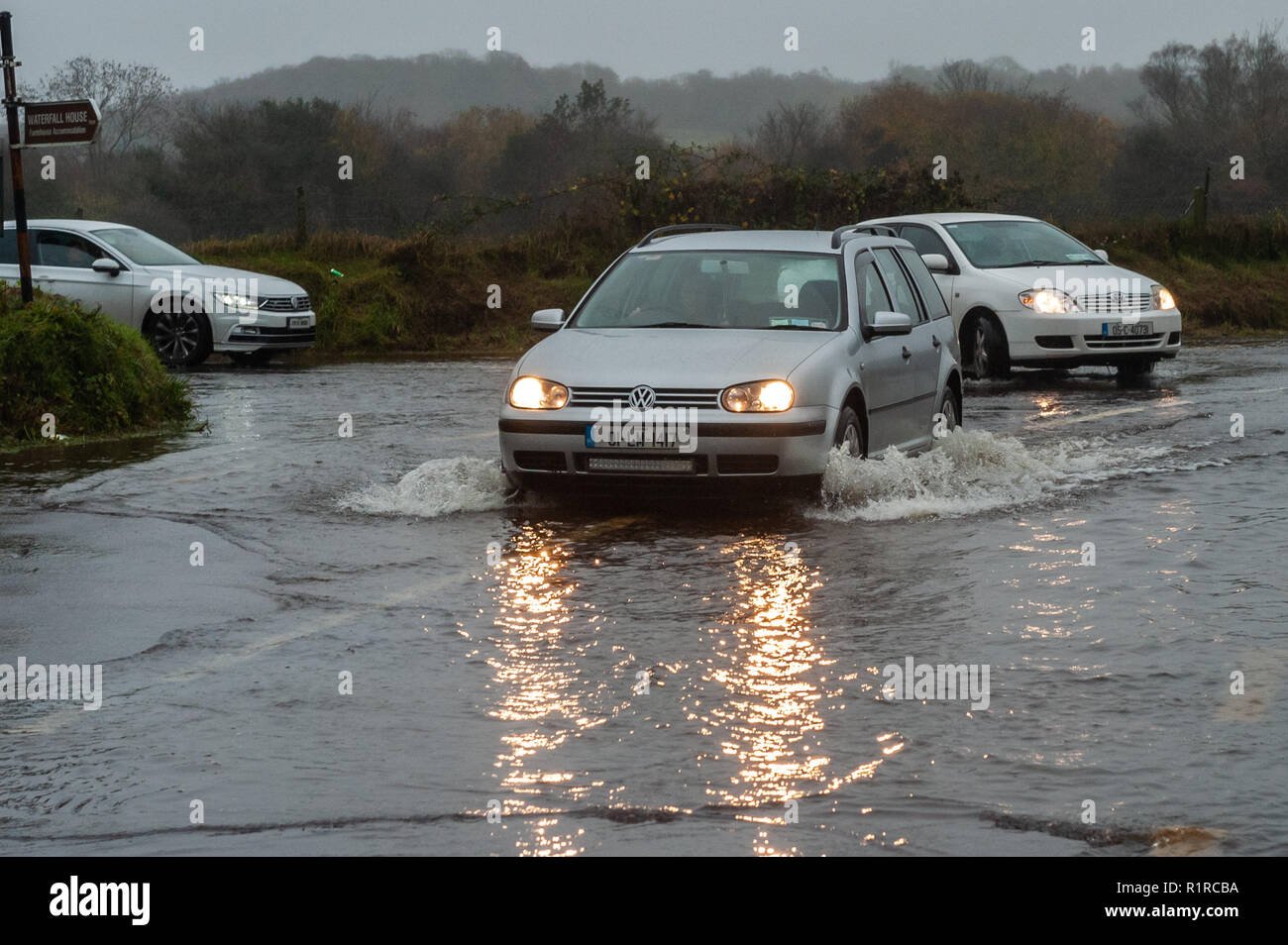 Dunmanway, West Cork, Irland. 14 Nov, 2018. Ein Auto verhandelt eine schlecht überschwemmte Straße gerade außerhalb Dunmanway nach einer Nacht von sintflutartigen Regenfällen. Der Tag wird sehr nass und windig mit Höhen von 13 bis 15°C. Credit: Andy Gibson/Alamy Leben Nachrichten. Stockfoto