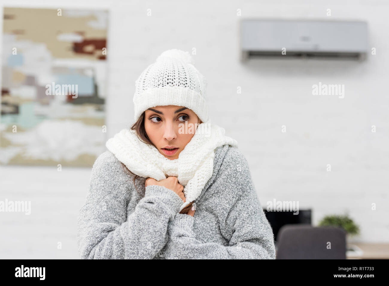 Close-up Portrait von Einfrieren junge Frau in warme Kleidung mit Klimaanlage auf Hintergrund Stockfoto