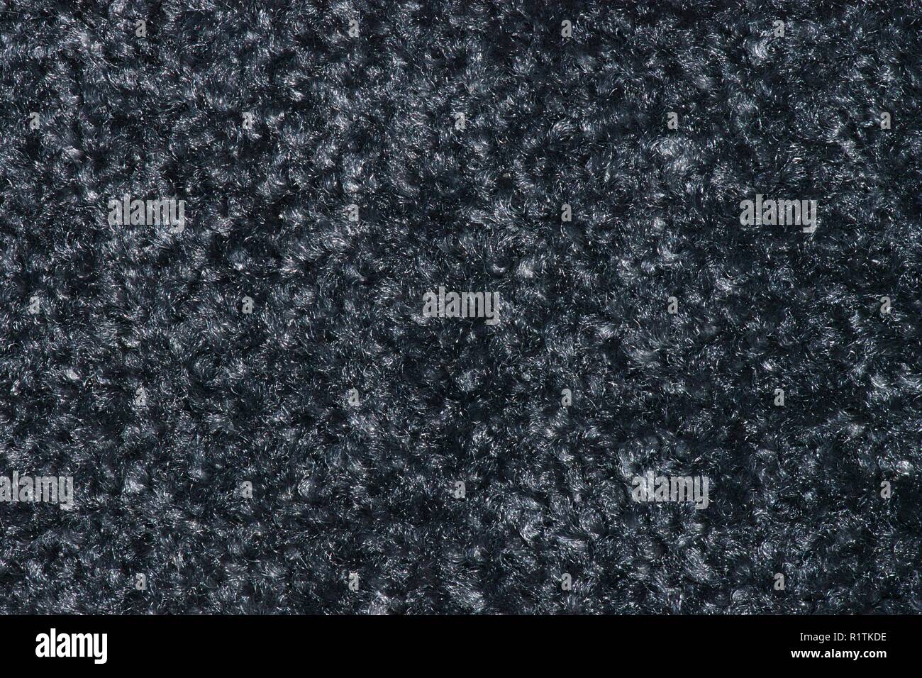 Textur einer Swatch aus dicken Rauchig schwarz Fußmatte mit hellem grauen Flecken. Stockfoto