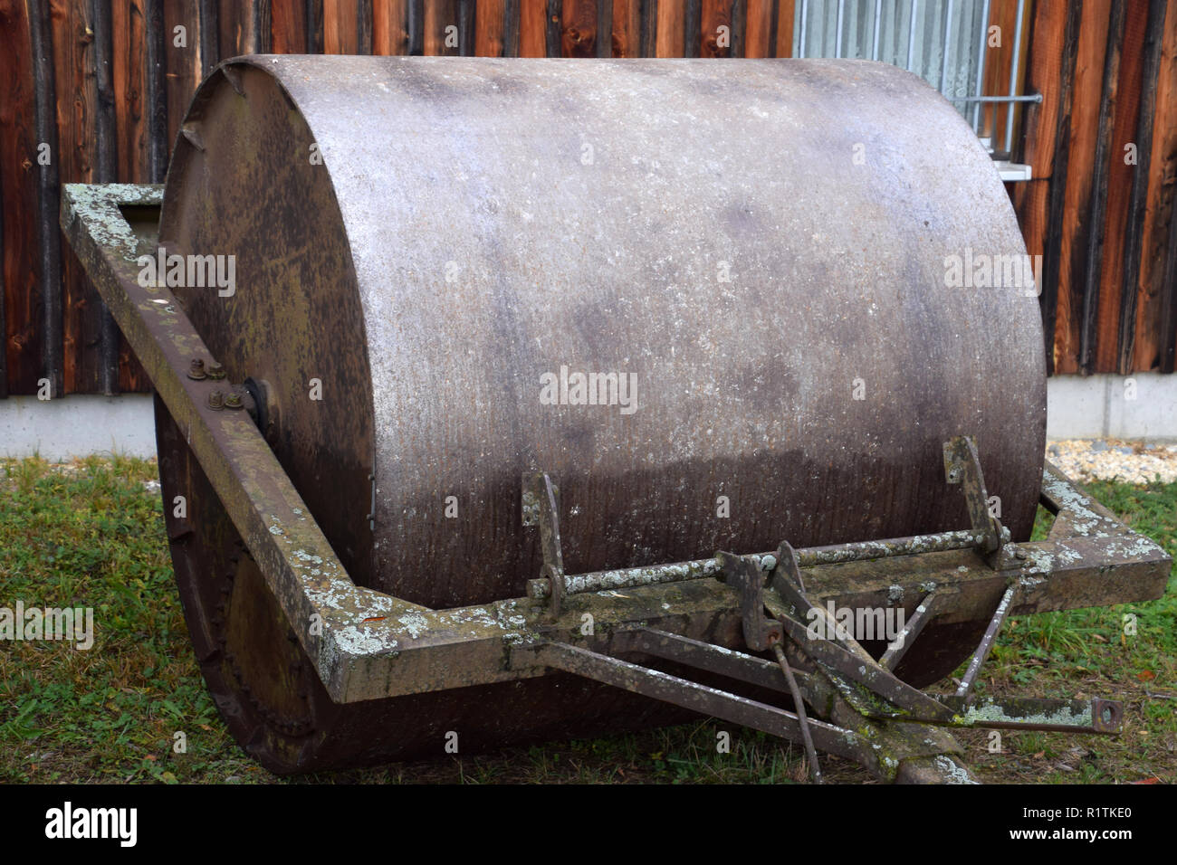 Metall farm Walze ländliche Szene Hintergrund, alt und rostiges Metall farm Roller aus schwerem Eisen Stockfoto