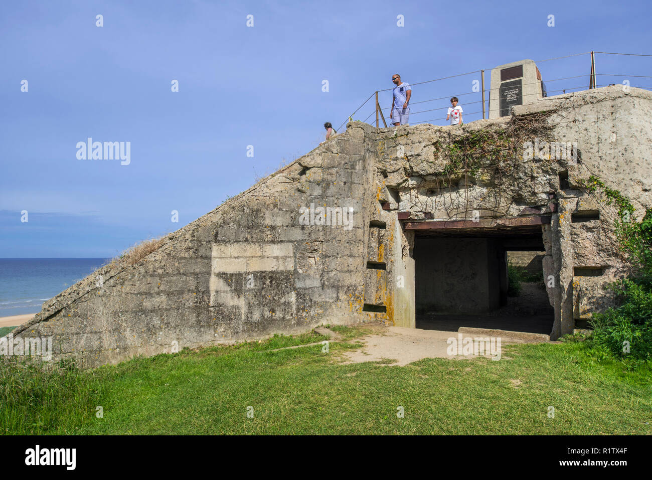 Touristen, die in der fünften Ingenieur spezielle Brigade Memorial auf deutschen Bunker am Omaha Beach, Colleville-sur-Mer, Calvados, Normandie, Frankreich Stockfoto
