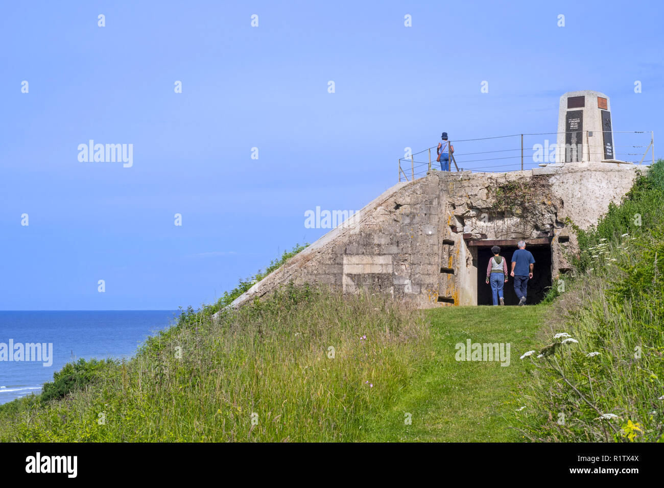 Touristen, die in der fünften Ingenieur spezielle Brigade Memorial auf deutschen Bunker am Omaha Beach, Colleville-sur-Mer, Calvados, Normandie, Frankreich Stockfoto