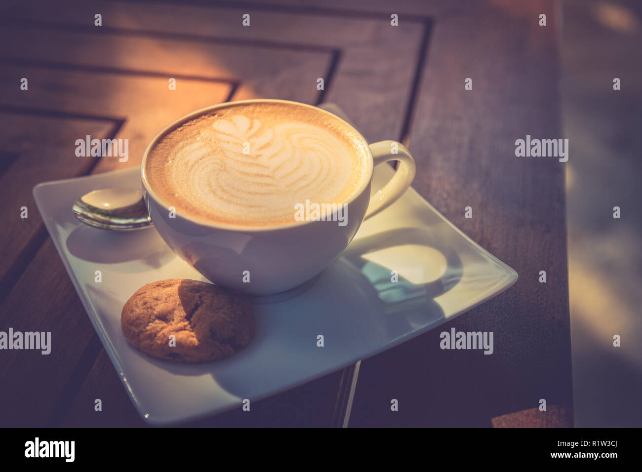 Schönen Morgen Holz- Tisch mit Kaffee, Latte Art und Cookie. Beginnen Sie den Tag, gute Laune Konzept. Stockfoto