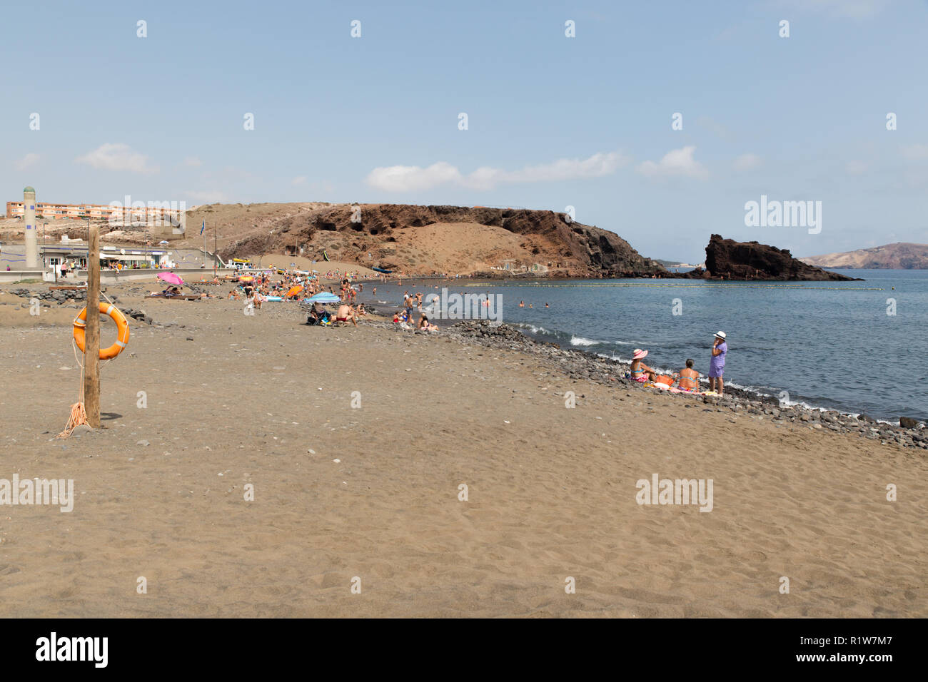 El Burrero in Gran Canaria, mit Personen, Aktivitäten, Schwimmen, Angeln, Schnorcheln oder einfach nur Ausruhen, durch den Kieselstrand Stockfoto