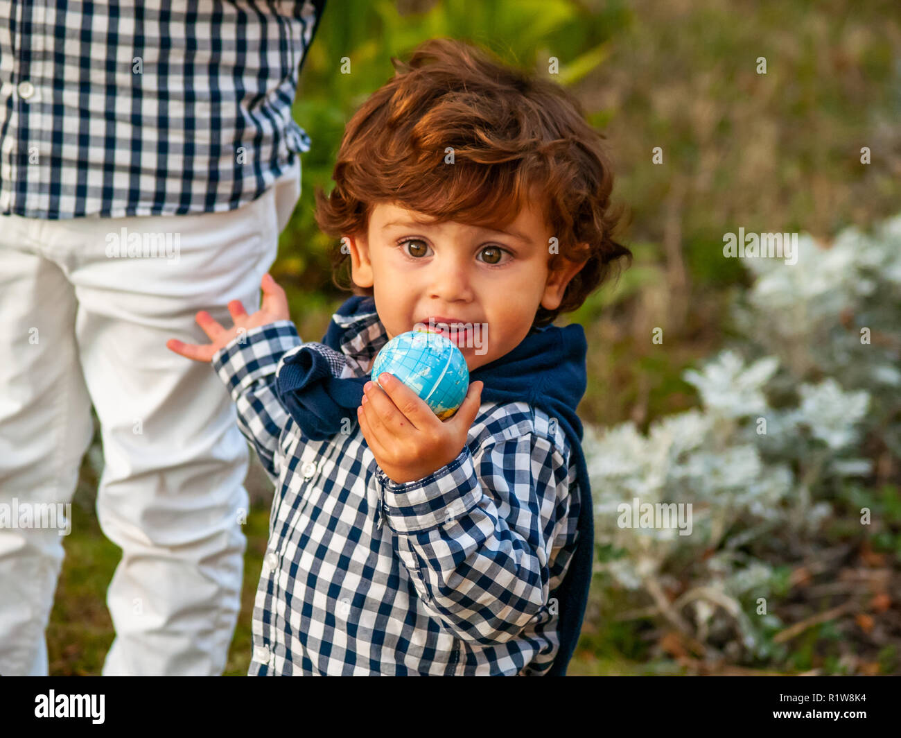 Ein Kind mit einer Kugel der Welt oder den Planeten Erde in seiner Hand. Ökologiekonzept Stockfoto