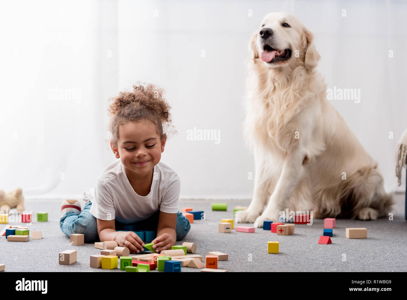 Adorable african american Kind spielen mit Spielzeug Würfel und Hund Stockfoto