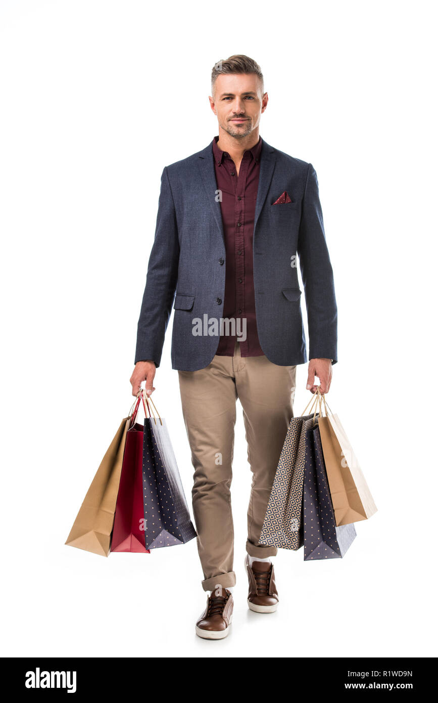 Stilvolle erwachsenen Mann in der Jacke mit bunten Einkaufstaschen isoliert auf weißem Stockfoto