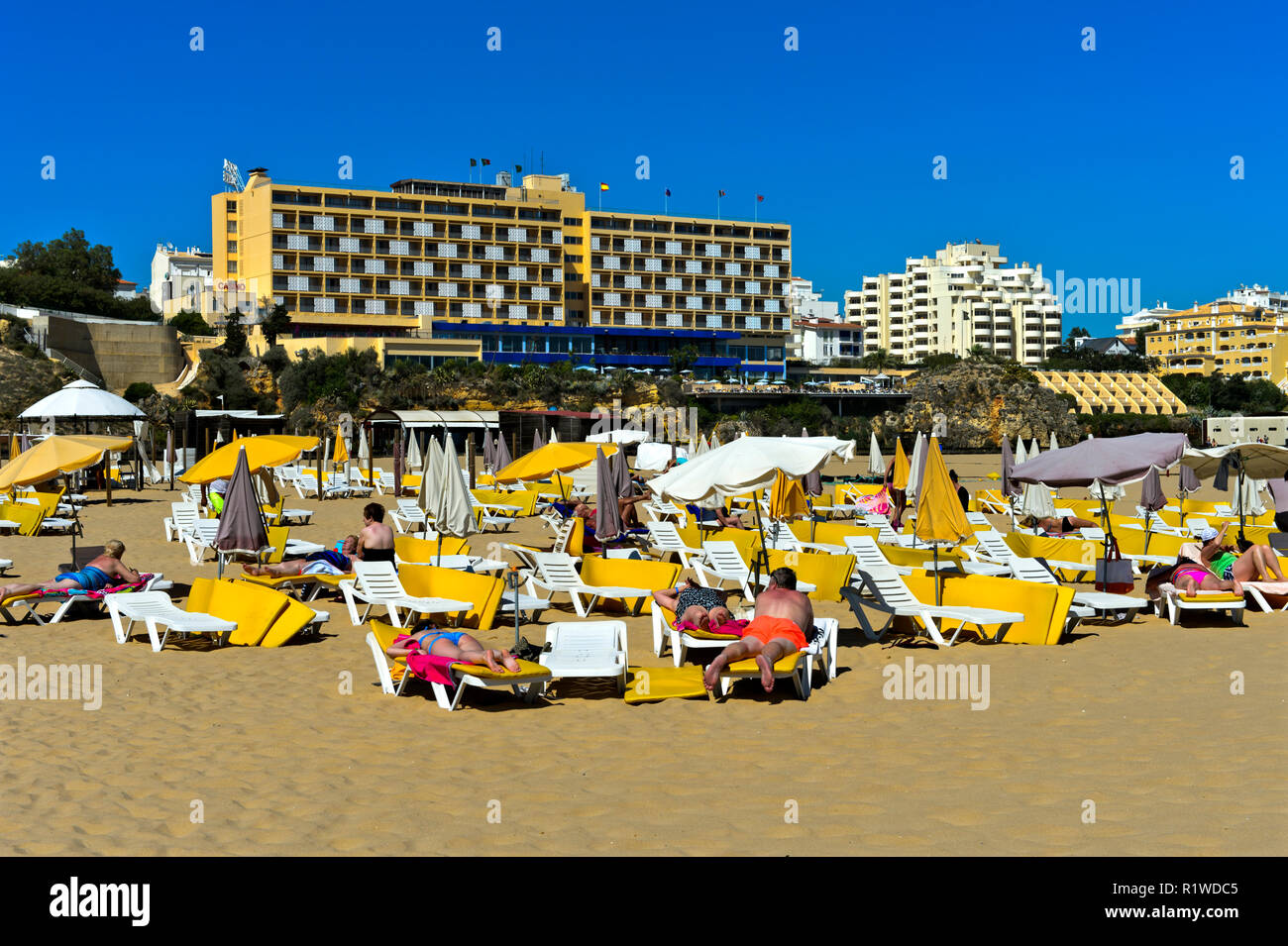 Touristen Sonnenbaden am Strand Praia da Rocha Praia da Rocha, Algarve Casino Hotel, Portimão, Algarve, Portugal Stockfoto
