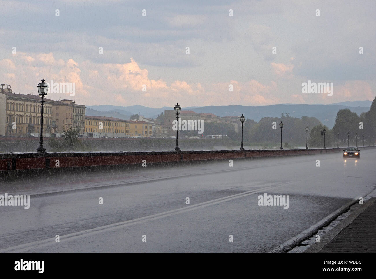 Andere Ansicht von Florenz, Italien - heftiger Platzregen Regen in San Niccolo in der Nähe von Ponte Alle Grazie neben dem Fluss Arno - Sonnenschein auf entfernte Wolken Stockfoto