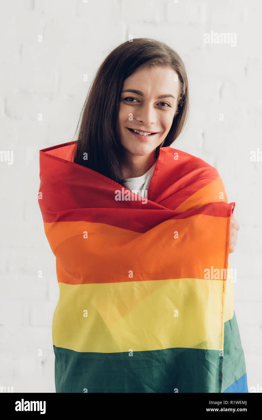 Happy transgender Menschen abdecken mit Stolz Flagge und Kamera vor der weißen Wand Stockfoto