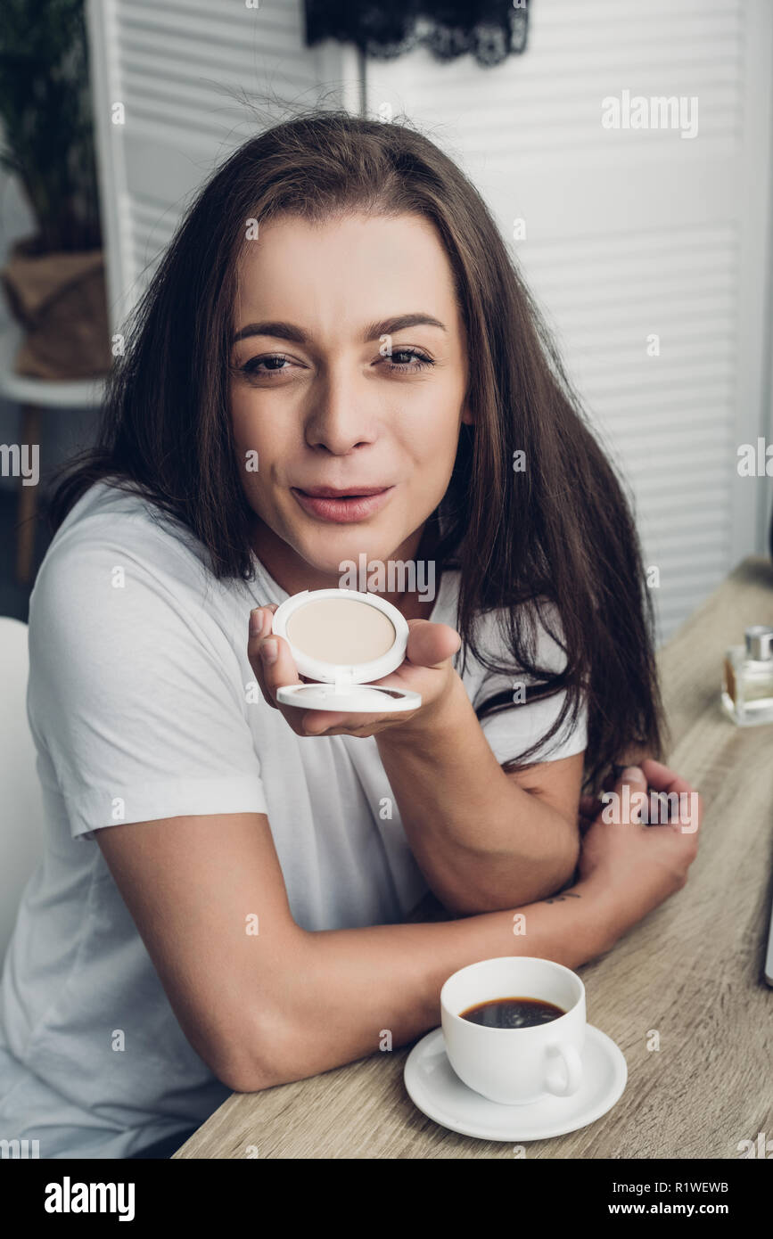 Close-up Portrait von lächelnden Jungen transgender Menschen weht makeup Blush an Kamera Stockfoto