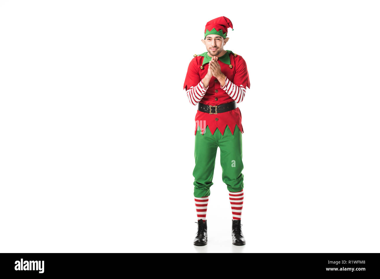 Aufgeregt Mann in Weihnachtself kostüm auf Kamera und reibt die Hände in Erwartung isoliert auf weißem Stockfoto