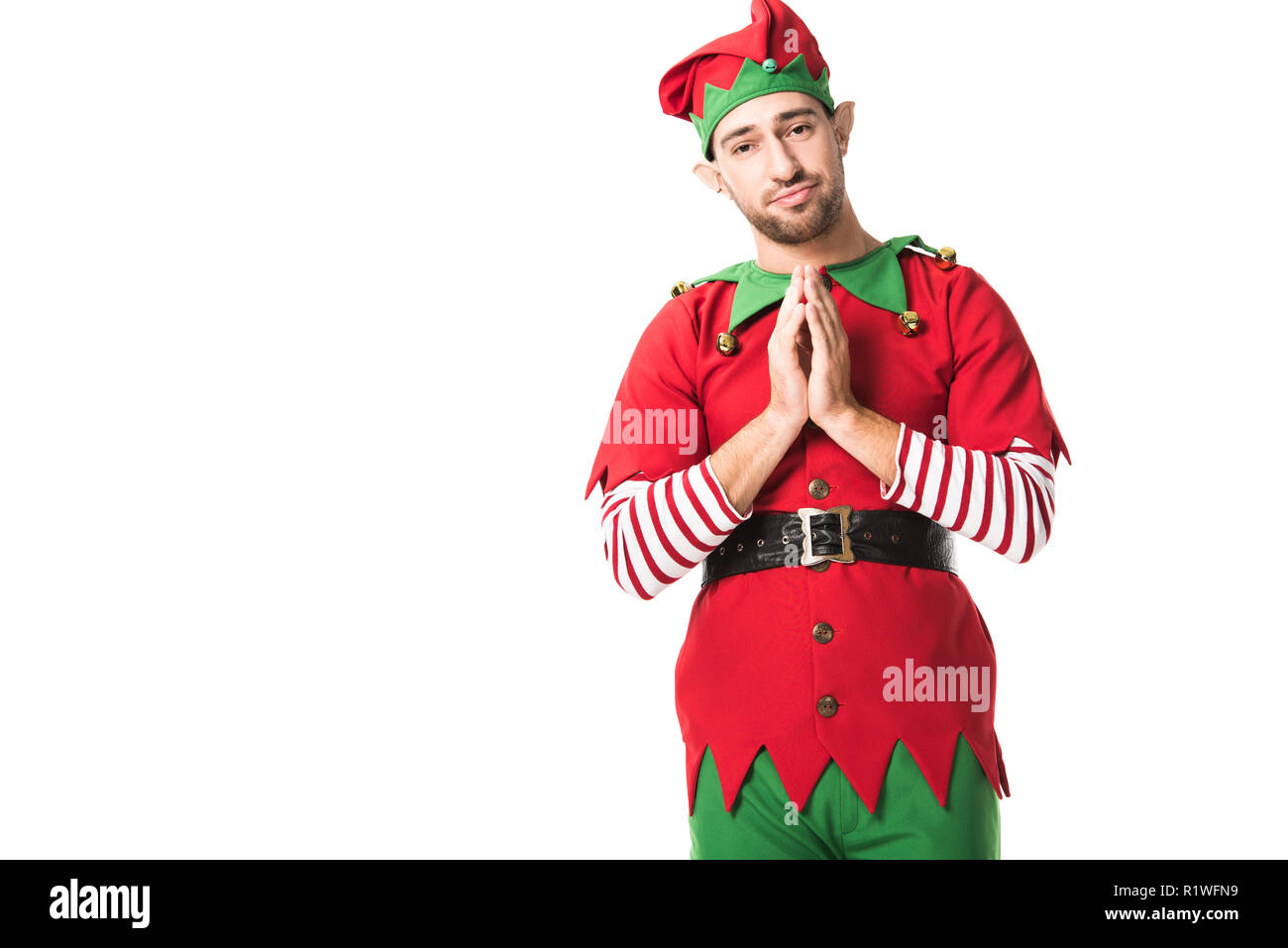 Mann in der Weihnachtself kostüm Holding Handflächen zusammen als bitte Geste und in hoffnungsvoller Ausdruck isoliert auf weißem Stockfoto
