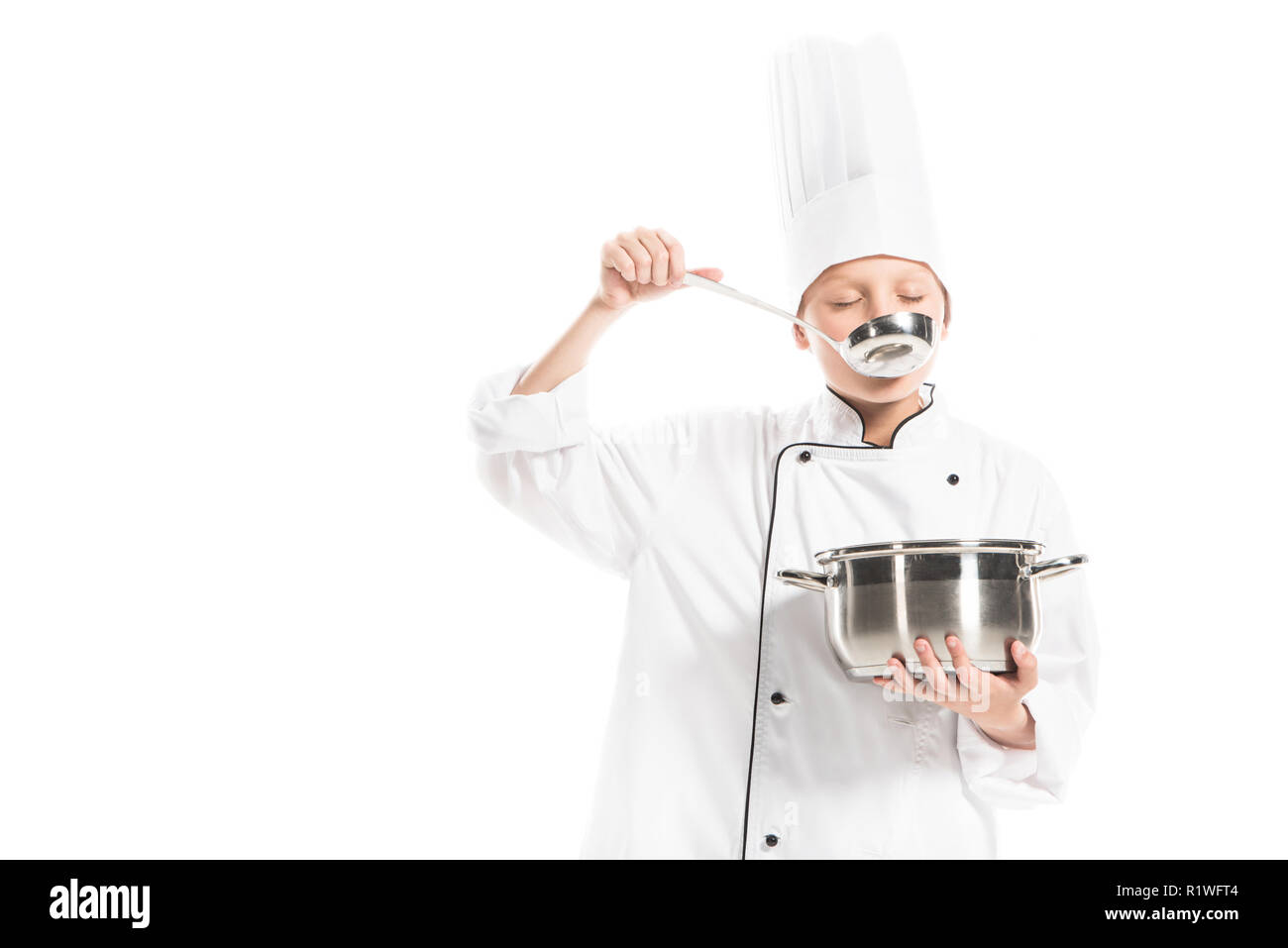 Pre-heranwachsenden Jungen in Chef Uniform mit Topf und Pfanne isoliert auf weißem Stockfoto