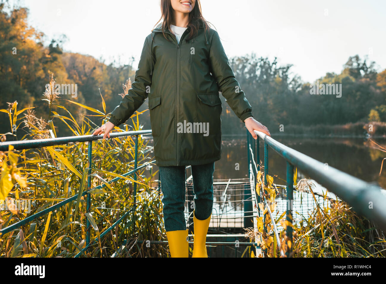 Teilweise mit Blick auf die junge Frau in Jacke und gelbe Gummistiefel in  der Nähe von Teich im Park posing Stockfotografie - Alamy