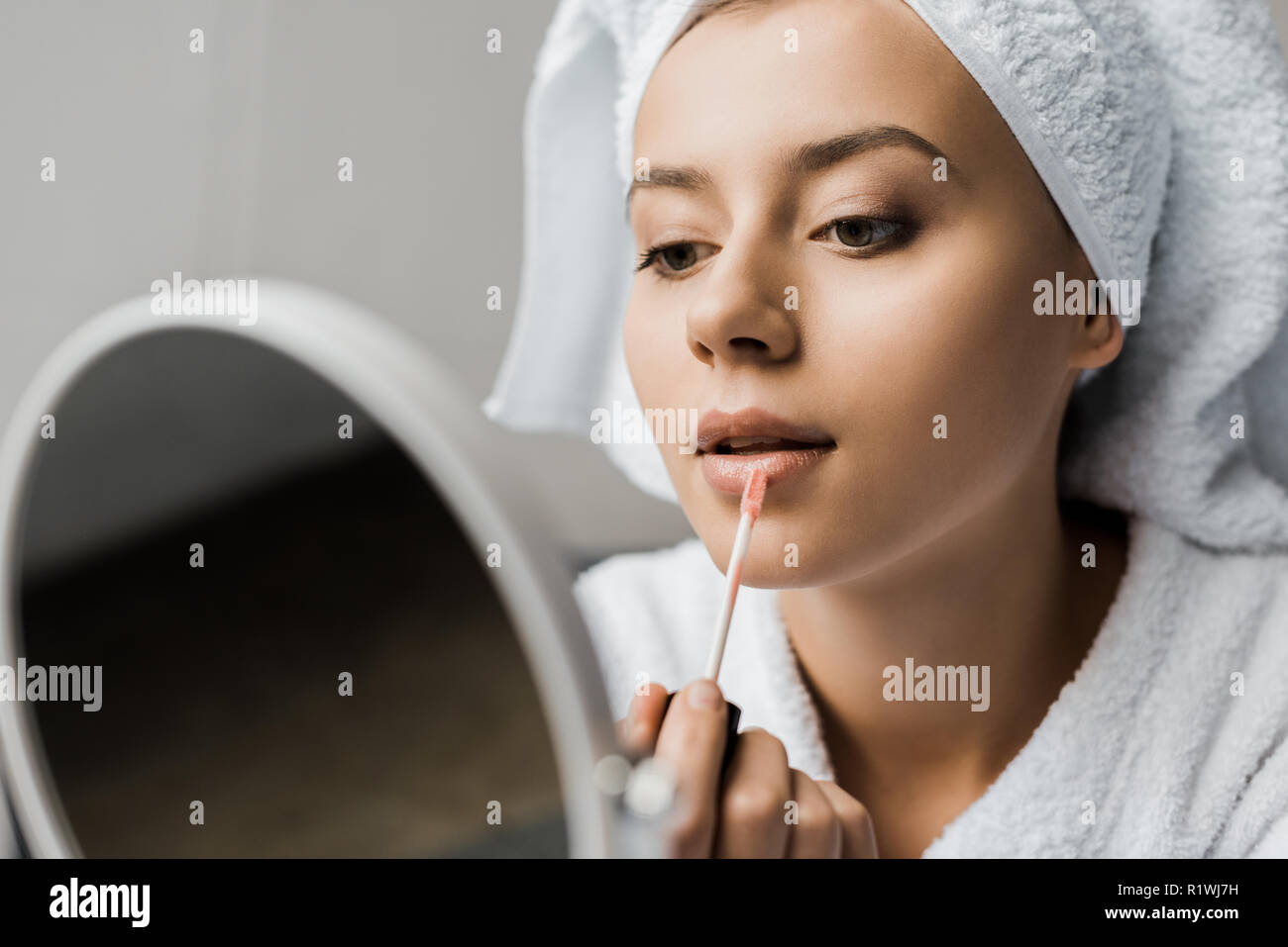 Schöne Mädchen, Lip Gloss und Spiegel Stockfoto