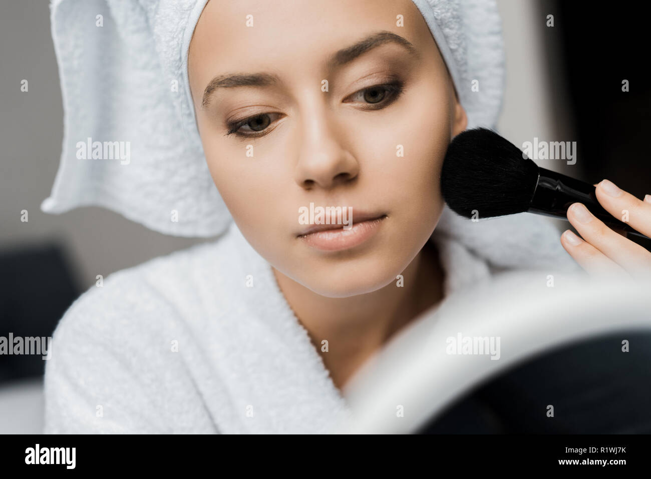 Schöne Mädchen in Bademantel und Badetuch Anwendung Pulver mit kosmetischen Bürste Stockfoto