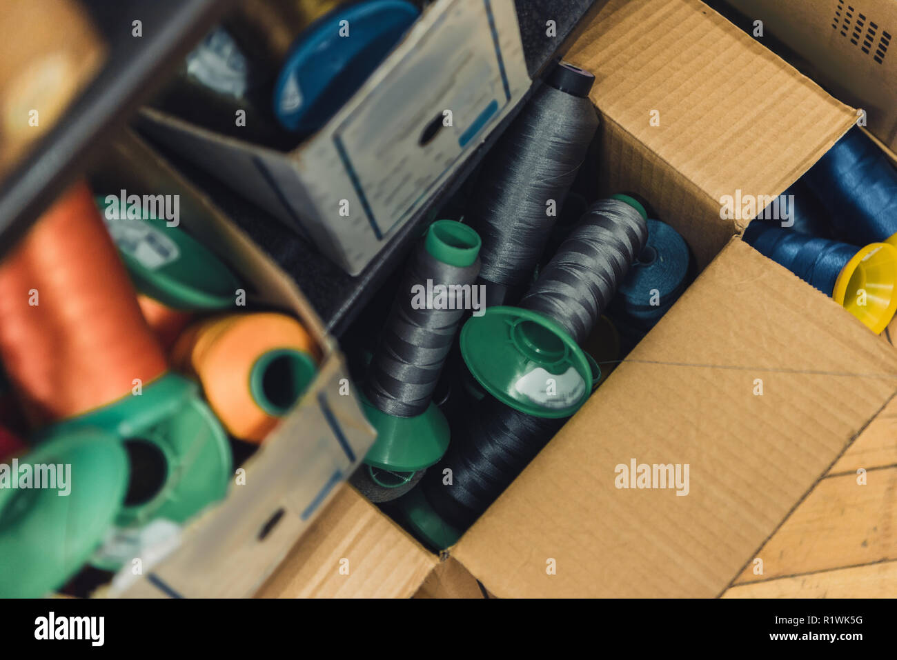 Hohe Betrachtungswinkel von verschiedenen nähen Strings in Kartons in Werkstatt Stockfoto