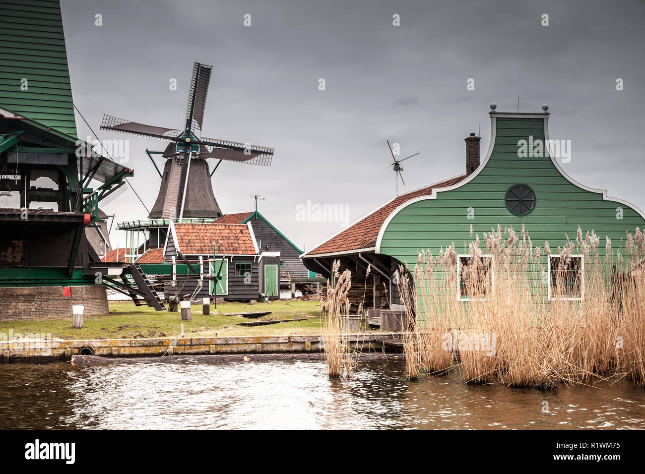Alte hölzerne Scheunen und Mühle am Fluss Zaan Küste. Zaanse Schans, beliebten touristischen Attraktionen der Niederlande. Vorort von Amsterdam Stockfoto