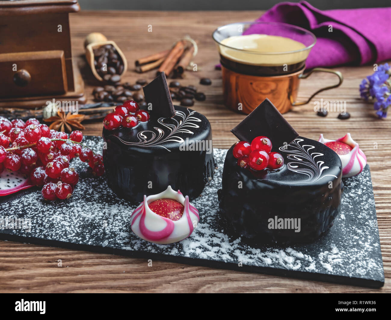 Schokoladenkuchen mit roten Johannisbeeren. Tasse Kaffee mit Dessert auf den Tisch Nahaufnahme Stockfoto