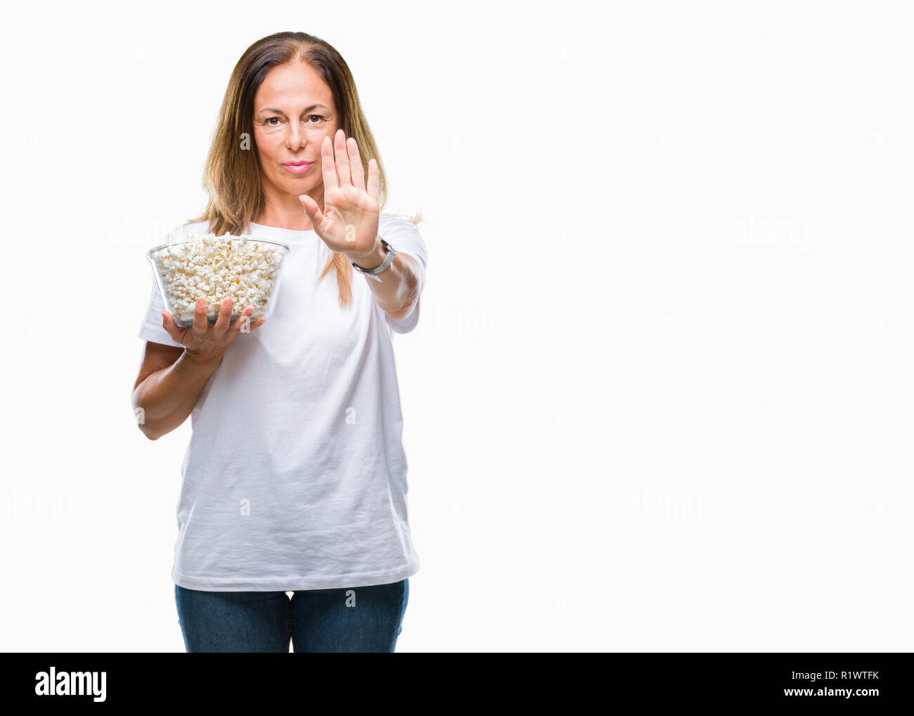 Mittleres Alter Hispanic Frau essen Popcorn über isolierte Hintergrund mit der offenen Hand tun, STOP-Schild mit ernsten und selbstbewussten Ausdruck, Verteidigung gestur Stockfoto