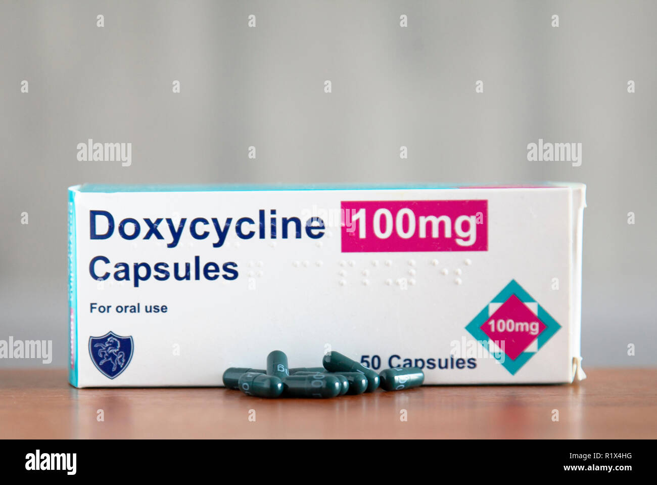 Foto von einem Kasten Doxycyline, ein Antibiotikum gegen mehrere infactions verwendet und als Malariamittel, mit einigen Kapseln in der Tabelle unten Lose. Stockfoto