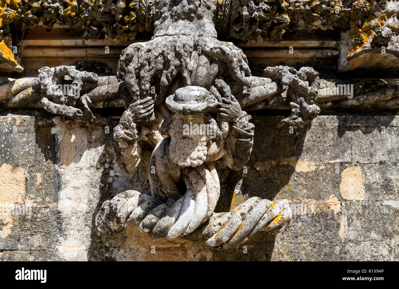 Detail der feinen Schnitzen einer Figur im unteren Abschnitt der manuelinischen Fenster des Klosters von Christus, in Tomar, Portugal Stockfoto