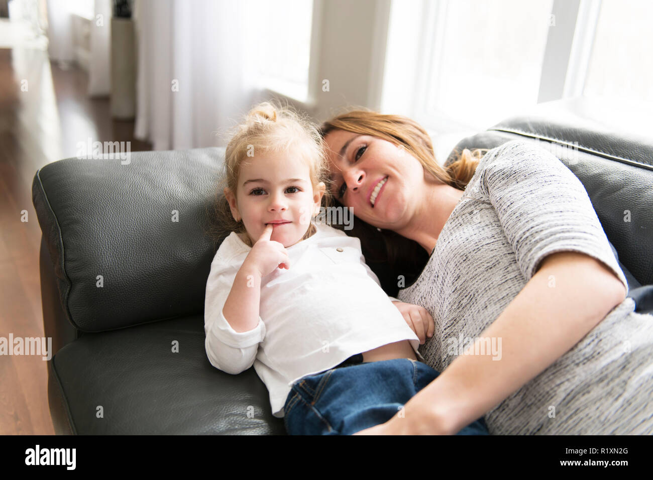 Eine glückliche Mutter mit ihrer Tochter im Wohnzimmer zu Hause. Stockfoto