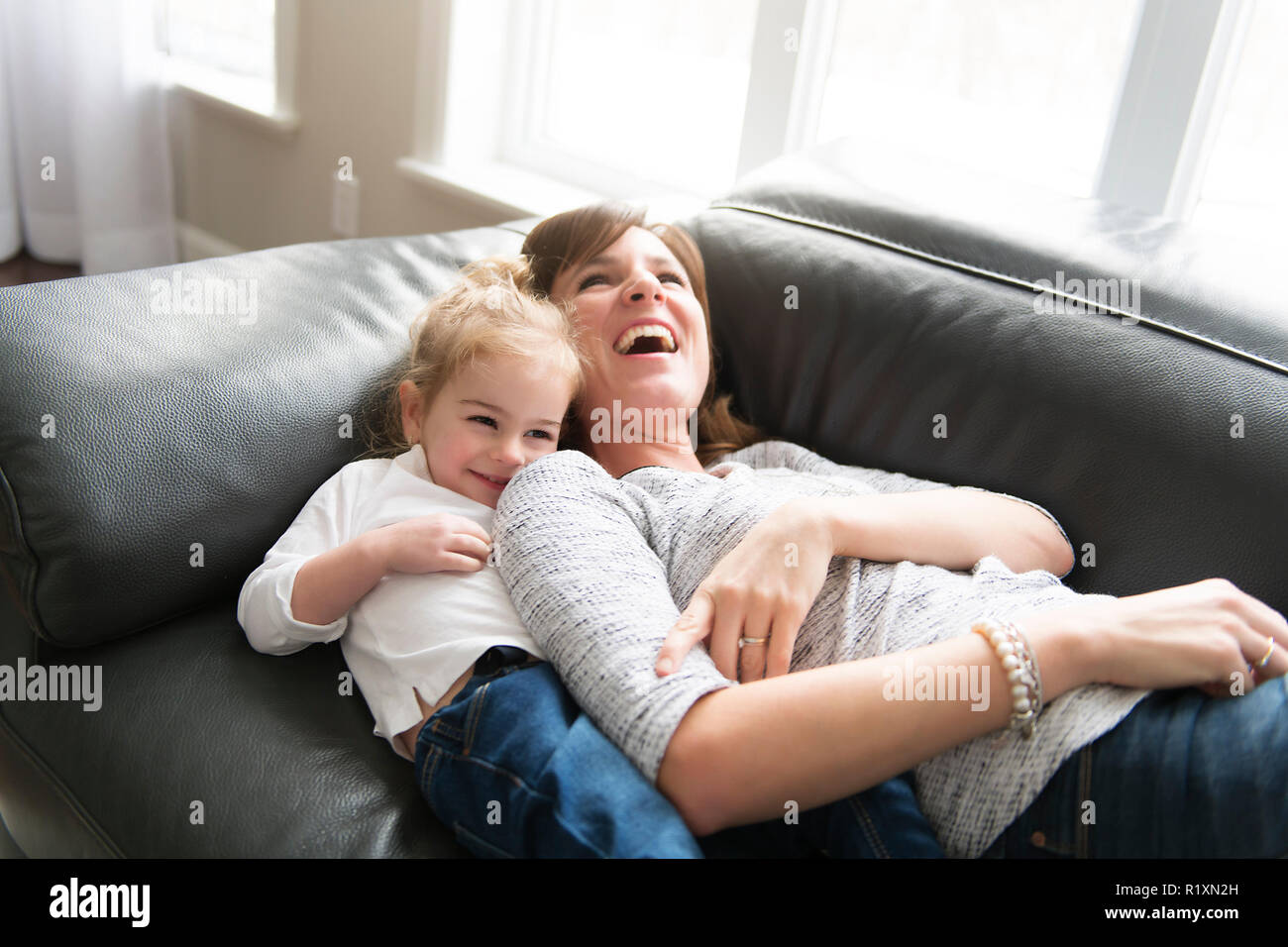 Eine glückliche Mutter mit ihrer Tochter im Wohnzimmer zu Hause. Stockfoto