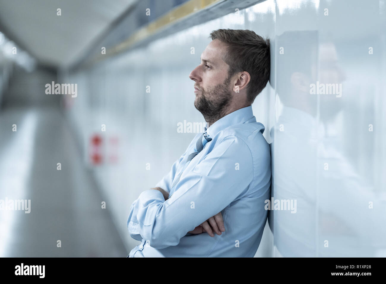 Der jungen Arbeitslosen business Mann leiden Depressionen lehnte sich auf Street U-Wand allein suchen verzweifelt in emotionalen Schmerz psychische Gesundheit Unemploymen Stockfoto