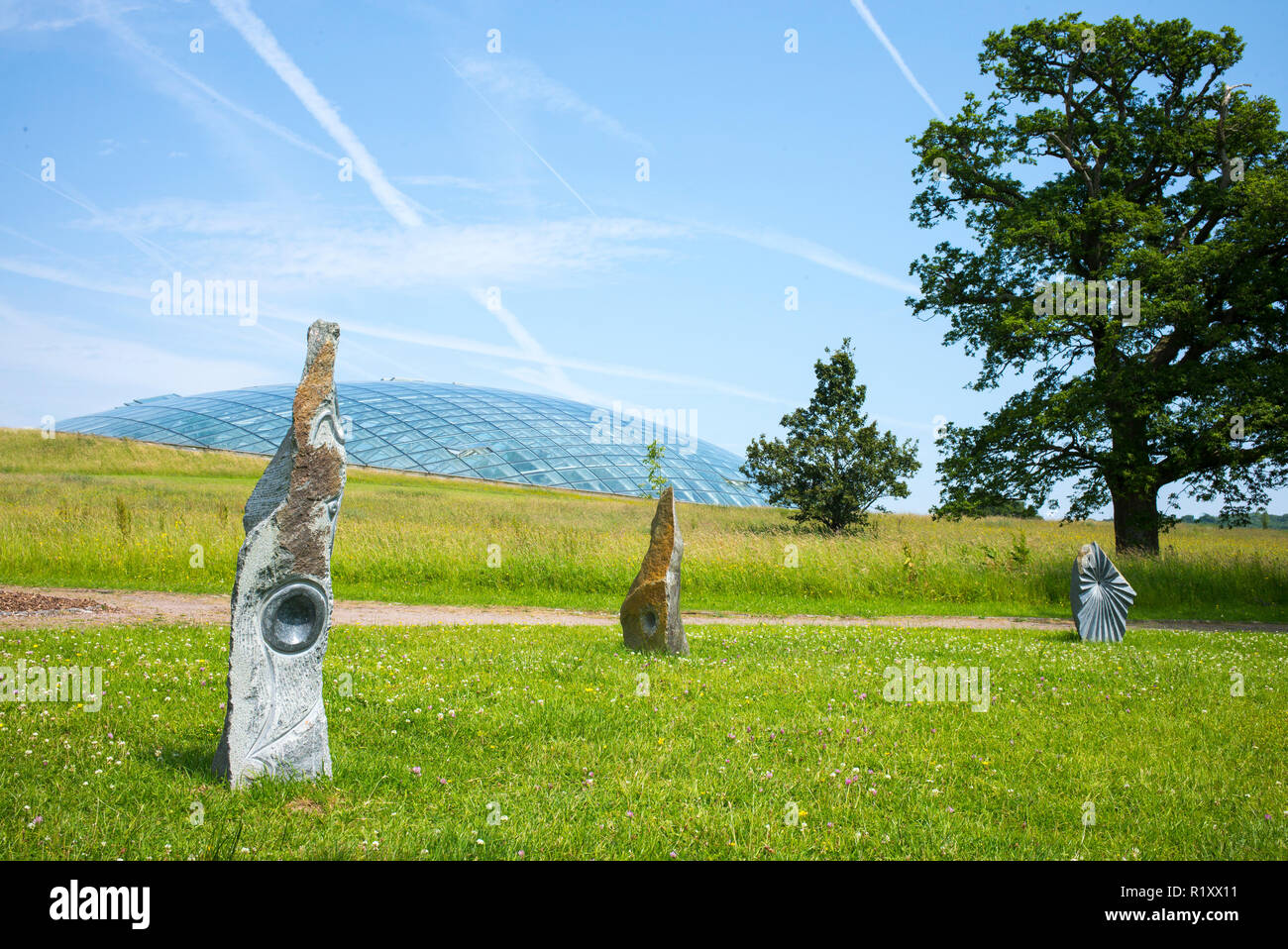 Dome Glas dach der Großen Gewächshaus des Nationalen Botanischen Garten von Wales und Skulpturen aus Stein. Stockfoto