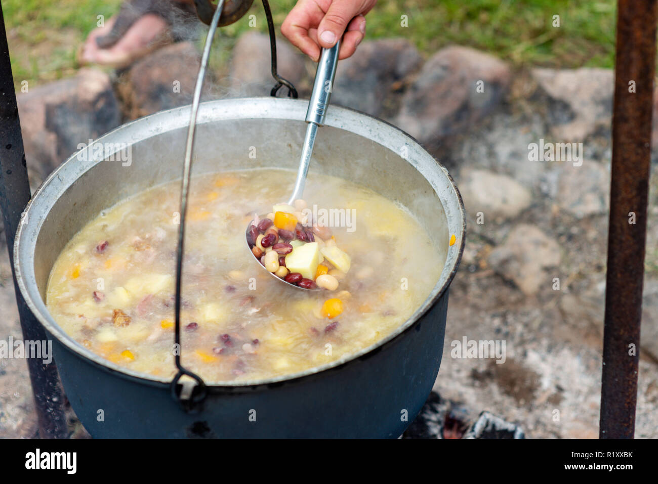 Kochen in einem Topf am Lagerfeuer. Sommer Camping Konzept. Stockfoto