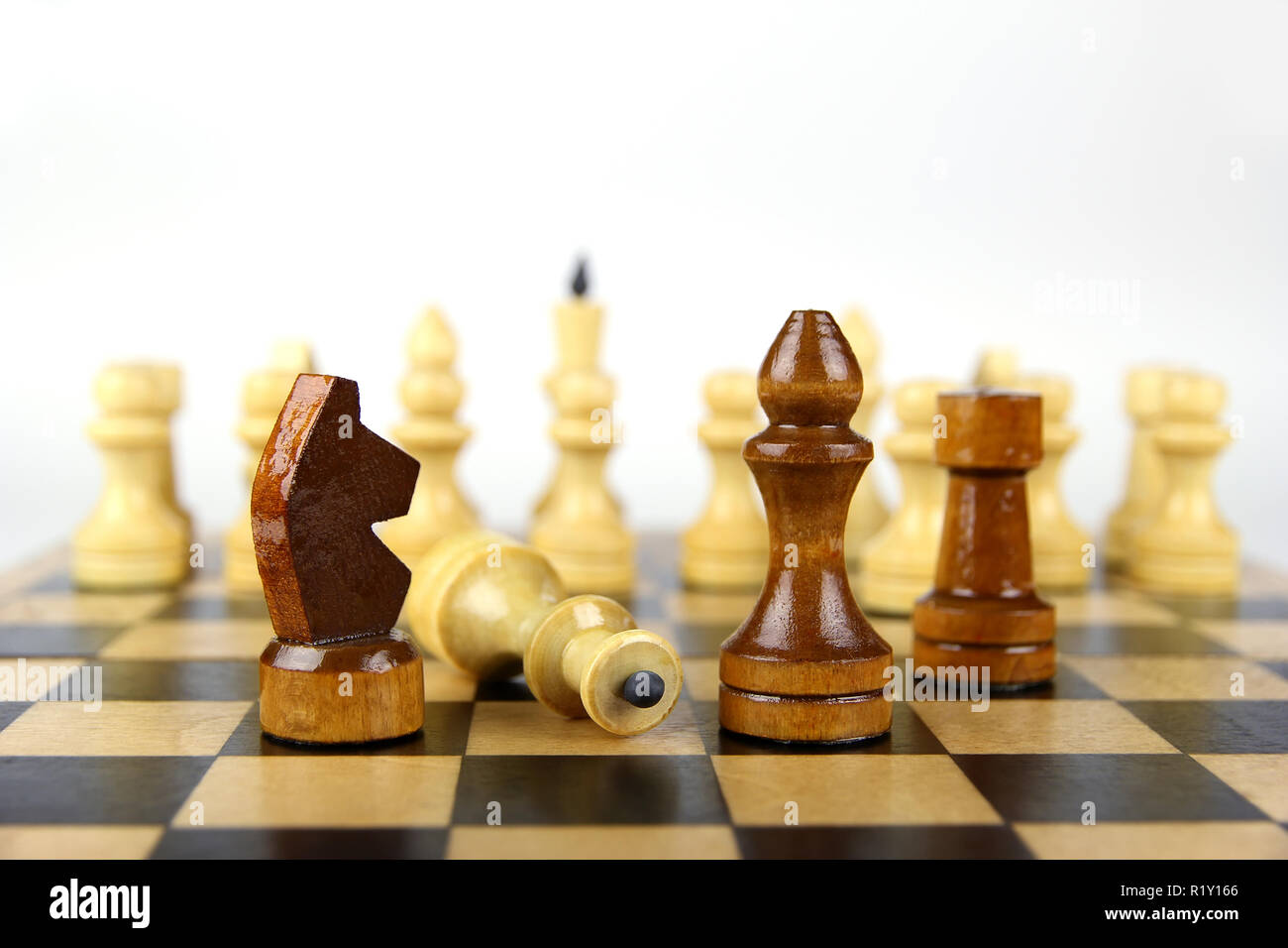 Hellen und dunklen Schachfiguren auf einem Schachbrett auf einem hellen Hintergrund Stockfoto