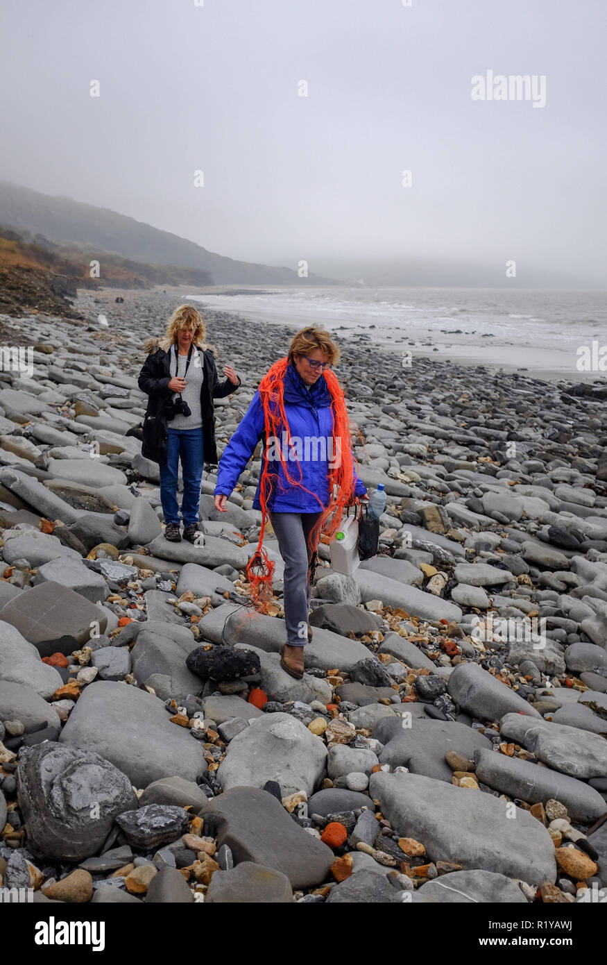 Lyme Regis DE 15. November 2018 - Wanderer bis Kunststoff und Abfall am Strand zwischen Lyme Regis und Charmouth auf einem nebligen trüben Nachmittag entlang der Jurassic Küste von Dorset: Simon Dack/Alamy leben Nachrichten Stockfoto